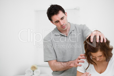 Physiotherapist moving the head of a brunette woman