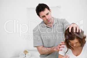 Physiotherapist moving the head of a brunette woman