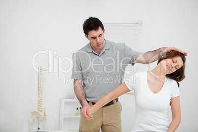 Osteopath stretching the arm of a woman