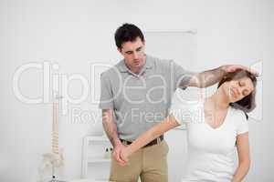 Osteopath stretching the arm of a woman
