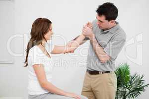 Serious practitioner touching the elbow of a woman