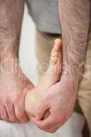 Doctor making a joint mobilisation on the ankle of a woman