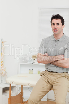 Peaceful osteopath sitting with arms crossed