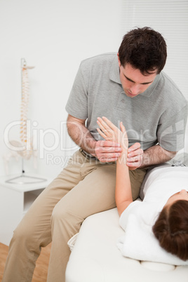 Physiotherapist placing his fingers on the hand of a patient