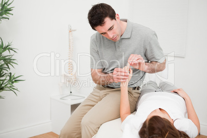 Physiotherapist moving the forefinger of a patient