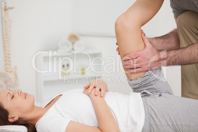 Physiotherapist holding the thigh of a patient