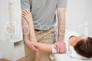 Physiotherapist pressing the shoulder of a woman