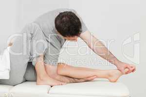 Brunette osteopath stretching a foot