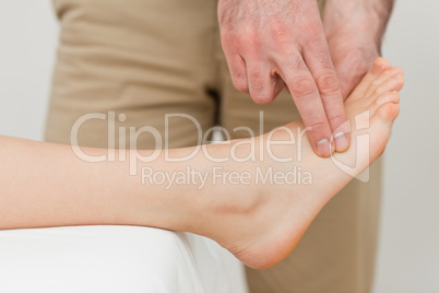 Fingers of a physiotherapist pressing on a foot