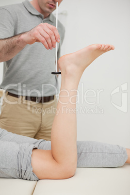 Serious practitioner using a reflex hammer
