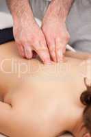 Osteopath massaging a woman in the middle of her back