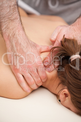 Shoulders of woman being squeezed while lying on a table
