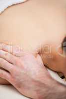 Shoulder of a woman being massaged by a doctor