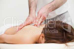 Therapist massaging the top of back of woman while standing