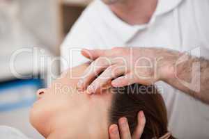 Doctor manipulating the side of the head of his patient