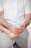 Podiatrist manipulating the foot of a woman while holding it on