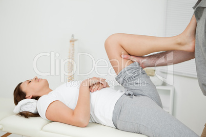 Woman putting her foot on the chest of her doctor while stretchi