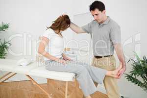 Physiotherapist manipulating his patient while standing