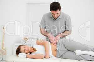 Peaceful woman being massaged on her hip by a doctor