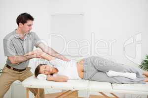 Chiropractor stretching the arm of his patient while holding it