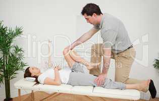 Woman being examining her leg by a chiropractor