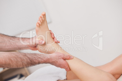 Podiatrist manipulating the ankle of his patient while holding i