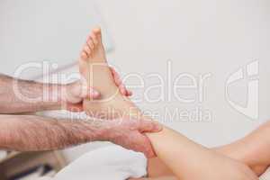 Podiatrist manipulating the ankle of his patient while holding i