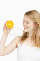 Joyful woman holding an orange