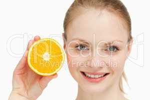 Close up of a smiling woman presenting an orange