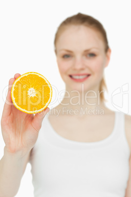 Blonde-haired woman holding an orange