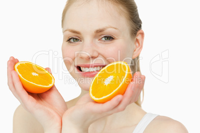 Close up of a cheerful woman holding oranges