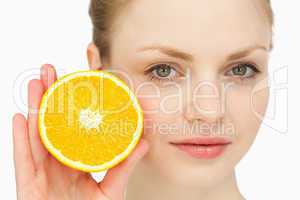 Close up of a woman presenting an orange