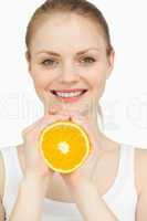 Smiling woman holding an orange in her hands