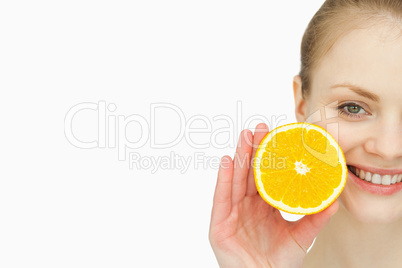 Close up of a woman holding an orange in her hand