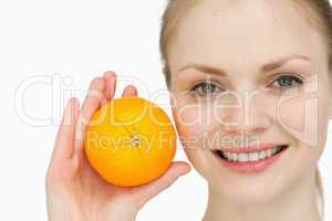 fair-haired woman holding an orange