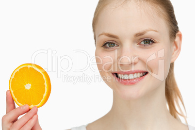 Smiling woman presenting an orange slice