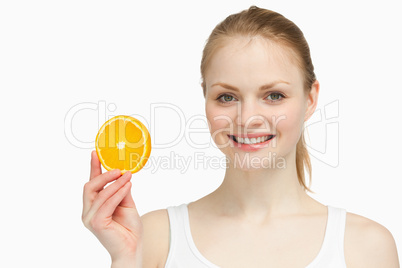 Cheerful woman presenting an orange slice