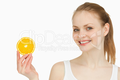 Cheerful woman holding an orange slice