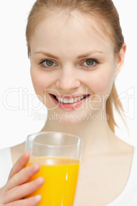 Smiling woman holding a glass of orange juice