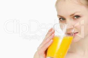 Young woman drinking a glass of orange juice