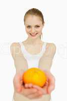 Smiling woman presenting a tangerine