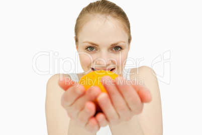 Blonde-haired woman holding a tangerine