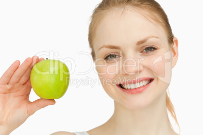 Blonde-haired girl smiling while holding an apple