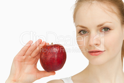 Young blonde-haired woman presenting an apple