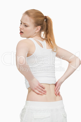 Young woman massaging her back