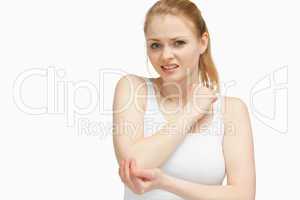 Fair-haired woman touching her elbow