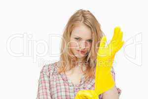 Woman frowning while putting cleaning gloves