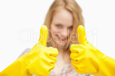 Woman thumbs up while wearing cleaning gloves