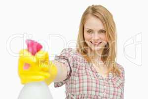 Woman holding a spray bottle while smiling