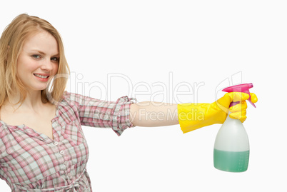 Smiling young woman holding a spray bottle